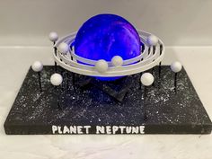 a blue ball sitting on top of a black base with white balls around it and the words planet refture