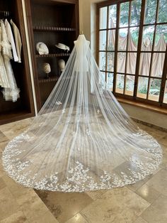 a white wedding veil hanging in front of a window