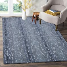 a blue rug with white polka dots on it in a living room area next to a chair