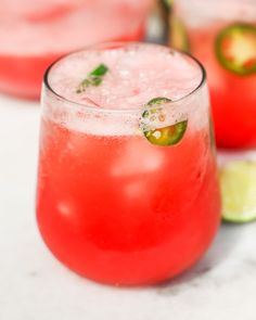 a close up of a drink in a glass with lime and pepper on the rim