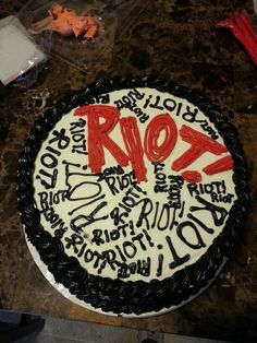 a white and black cake with red writing on it