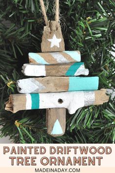 painted driftwood tree ornament hanging on a christmas tree with text overlay that says painted driftwood tree ornament