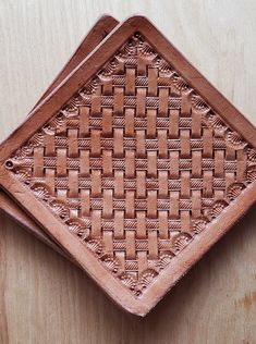 two brown woven coasters sitting on top of a wooden table next to each other