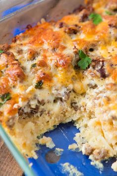 a casserole with meat and cheese is cut in half on a blue plate