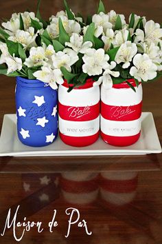 three patriotic mason jars with flowers in them on a plate that says maison de pax