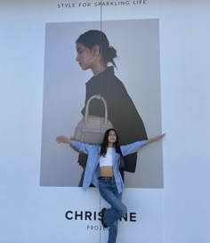 a woman standing in front of a large advertisement