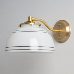 a white and gold light fixture on the wall