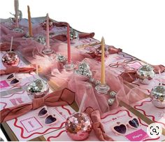 a table topped with lots of pink and silver items