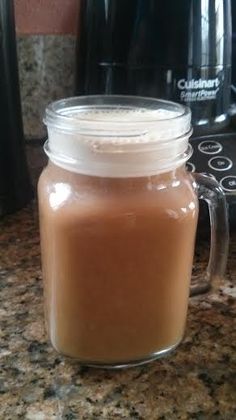 a glass jar filled with liquid sitting on top of a counter next to an air fryer