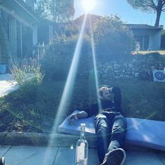 a man laying on top of a blue mat next to a bottle