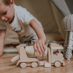 a young boy playing with wooden toys on the floor