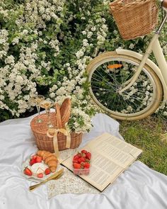 an open book sitting on top of a table next to a basket filled with strawberries