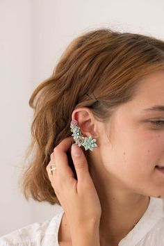 a woman wearing ear clips with flowers on them