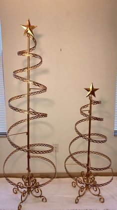 two metal christmas trees sitting next to each other