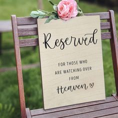 a wooden sign that says reserved for those who are watching over from heaven is sitting on a bench