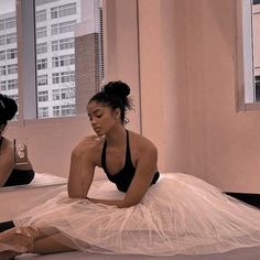 two women in black and white dresses sitting on the floor