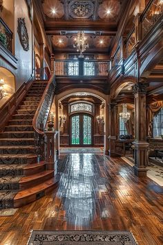 a large foyer with wooden floors and chandeliers on either side of the staircase