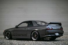 a gray car parked in front of a garage door