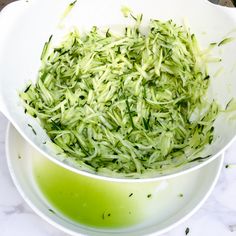 a white bowl filled with green liquid on top of a table