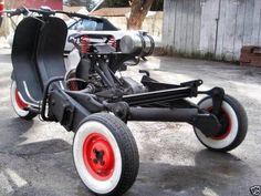 an unusual looking vehicle is parked in the parking lot next to a car that has red wheels