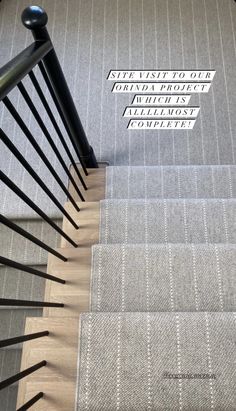 the stairs are lined with black railings and white carpeted stair treads, which have words written on them