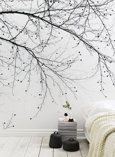 a bedroom with a tree wallpaper and white walls