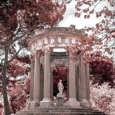 a statue in the middle of a park surrounded by trees