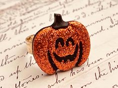 A pumpkin charm has adhered onto an adjustable gold plated ring.  The pumpkins charm is about 20x 21mm. Fits most sizes. Perfect for Halloween! ♥ See more Halloween jewelry here: https://www.etsy.com/shop/iceblues/items?ref=listing-shop-header-item-count§ion_id=10461899 GIFTS Each item is individually wrapped in a branded jewelry gift box. We do not include price receipts in the package. We are happy to ship directly to the recipient. EXPEDITED SHIPPING At checkout, you have the option to choose faster shipping in the drop-down menu. Ship times do NOT include production times. However, if you select expedited shipping, we will try to get your order completed faster. SHOP FAQs Please read my shop policies for my current production time and other information: http://www.etsy.com/shop/iceblue Glitter Pumpkins Halloween, Lantern Rings, Pumpkin Ring, Jewelry Chunky, Glitter Pumpkins, Teen Jewelry, Chunky Jewelry, Fall Jewelry, Halloween Jewelry