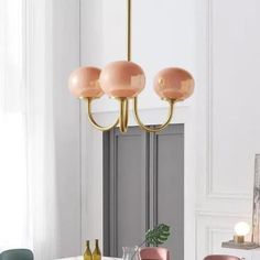 a dining room table with chairs and a chandelier hanging from the ceiling over it