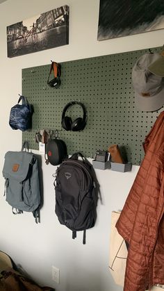 several backpacks and headphones hanging on a pegboard in a room with earbuds