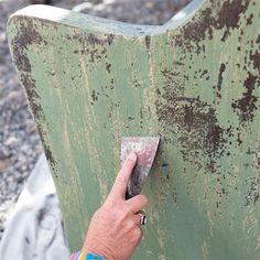 an old green chair being painted with rust