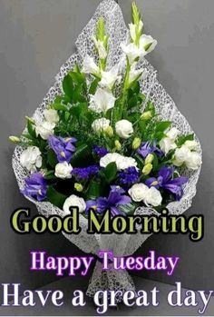 a bouquet of flowers sitting on top of a table with the words good morning happy tuesday have a great day