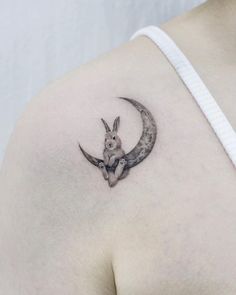 a rabbit is sitting on the moon tattoo