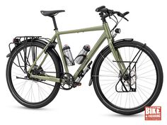 a green bike with black spokes on the front and back wheels, parked against a white background