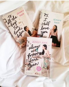 three books laying on top of a bed next to each other with writing on them