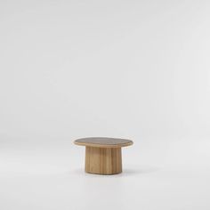 a round wooden table sitting on top of a white floor