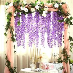 the table is covered with purple flowers and greenery for an elegant wedding ceremony decoration