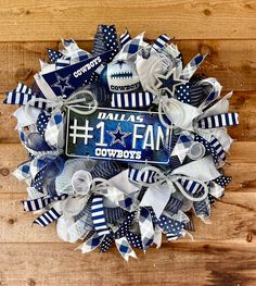 a wreath made out of blue and white football fan's hair bows with the number one fan on it