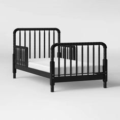 a black crib with white sheets on the bottom, and side rails to the sides