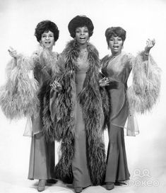 three women in long dresses and fur coats