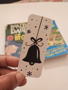 a person holding up a card with a bell on it