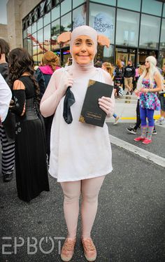 a woman dressed in costume holding a book