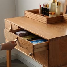 a wooden desk with drawers and cosmetics on it