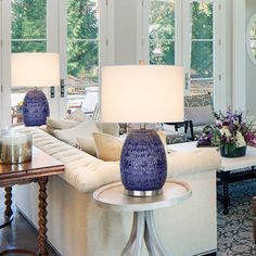 a living room filled with lots of furniture next to two lamps on top of tables