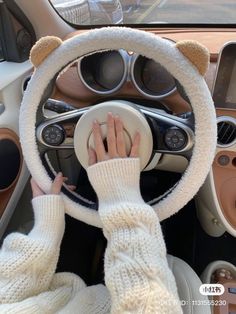 a person driving a car with their hands on the steering wheel while wearing white gloves