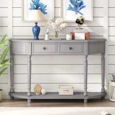 two blue vases sitting on top of a wooden table next to a white wall