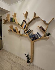 a bookshelf shaped like a tree in the corner of a room with wood floors