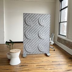 a room with wooden floors and a large white sculpture on the floor next to a potted plant