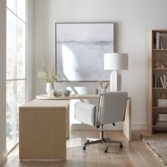 an office with a desk, chair and bookcase in front of a large window