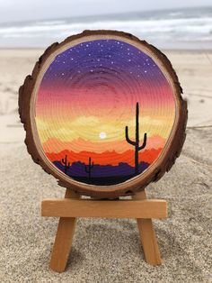 a painting on a piece of wood with a sunset in the background